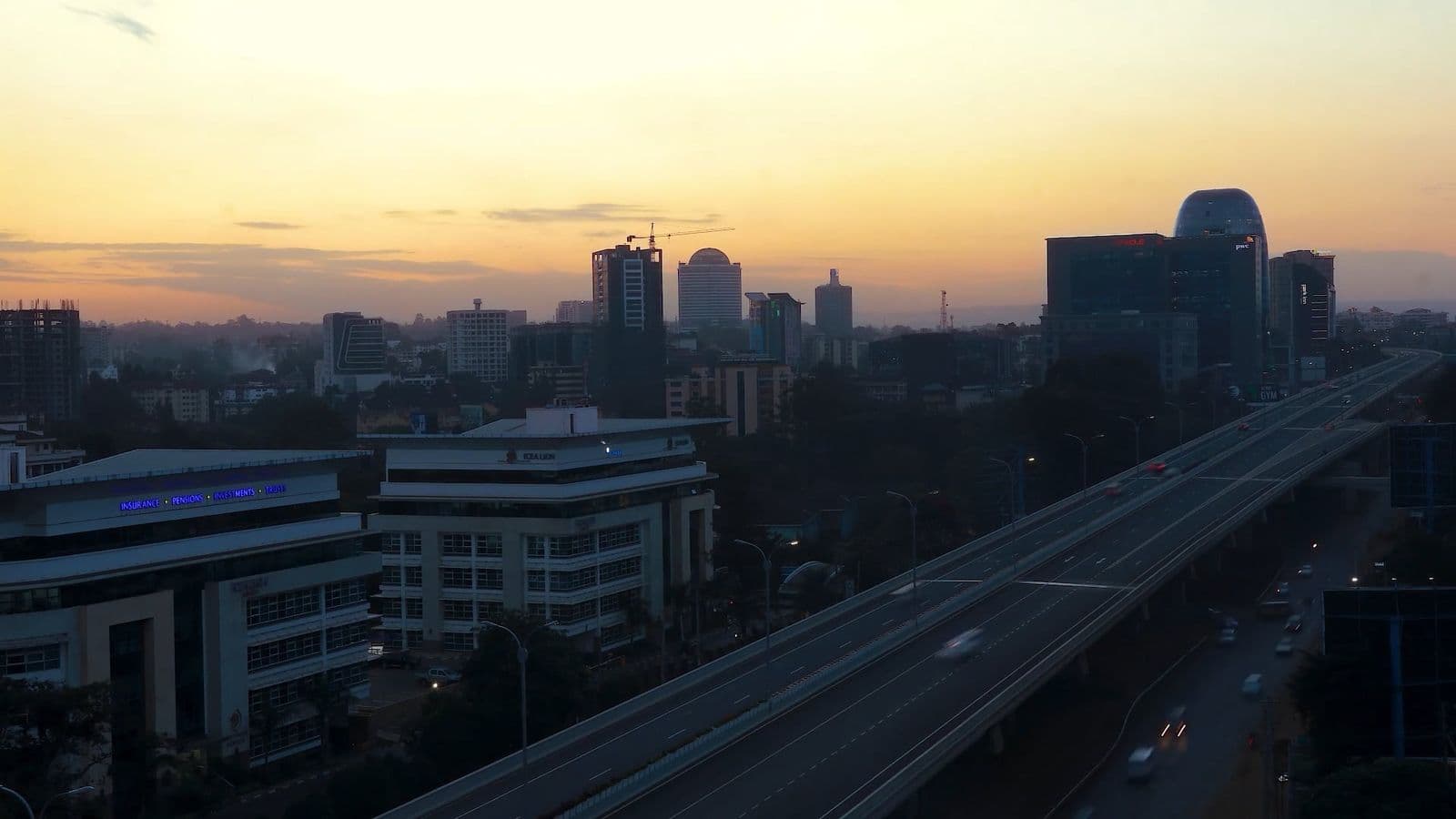 Westlands and the Nairobi Expressway at dusk, traffic streaming past the skyline